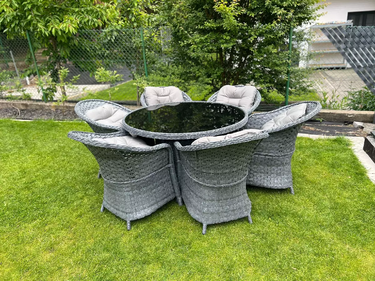 Komplet mebli z szarego technorattanu fotele ogrodowe, poduszki na siedziska i oparcie, okrągły stół.webp